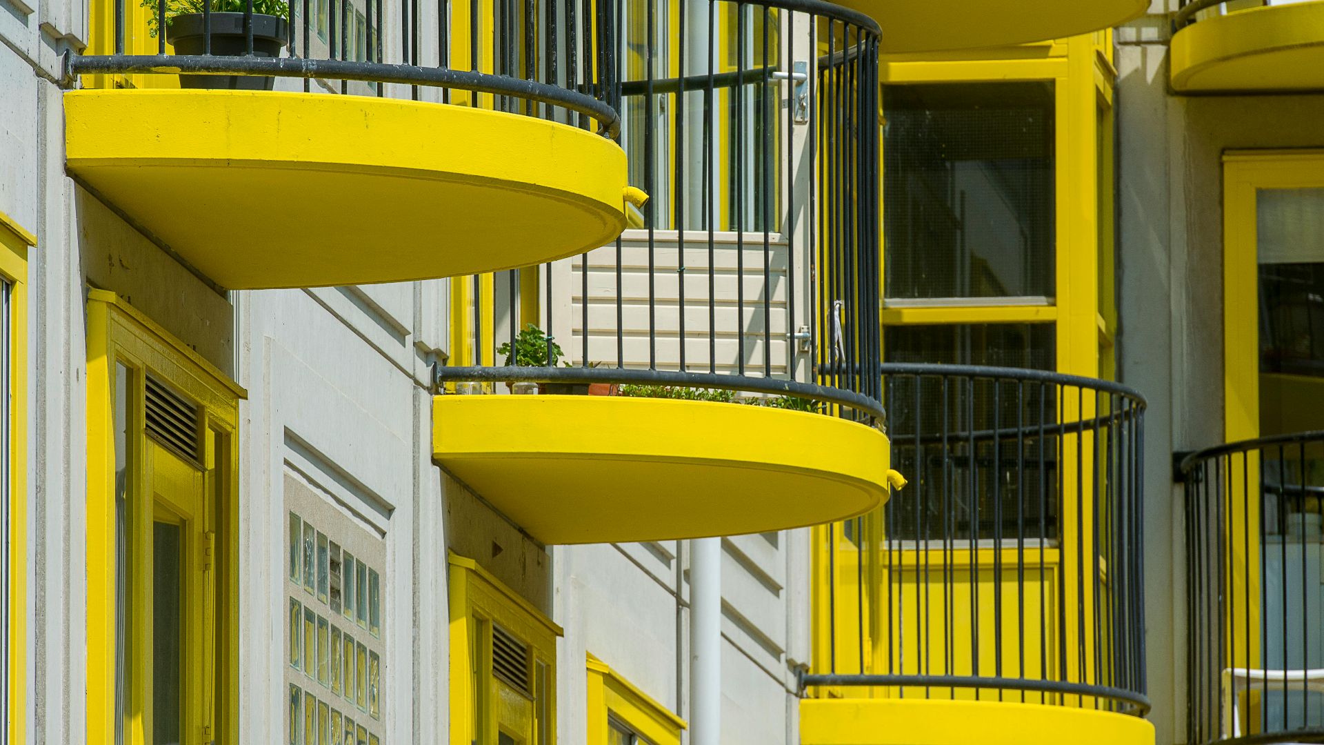 Close-up of modern yellow balconies on an urban apartment building facade.