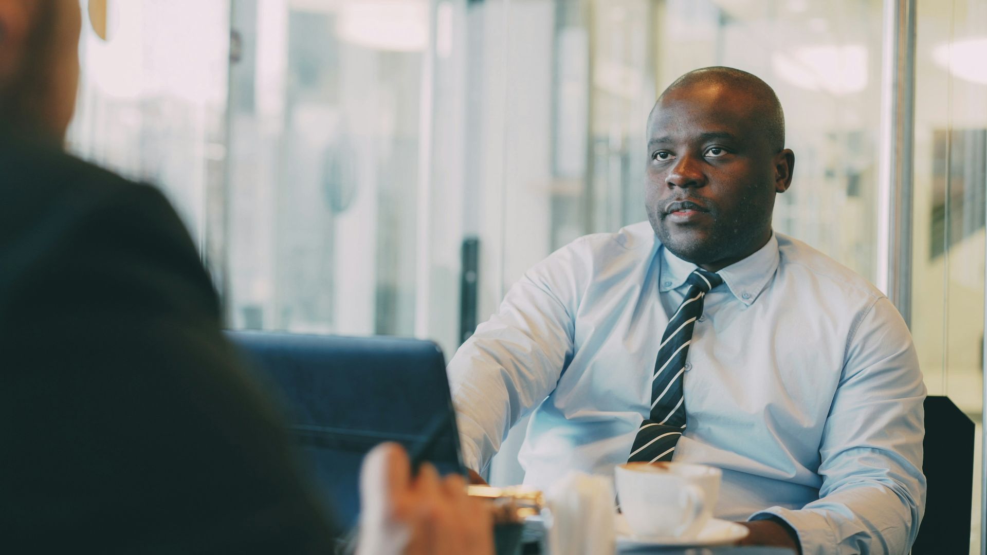 Two businessmen in a meeting with coffee.