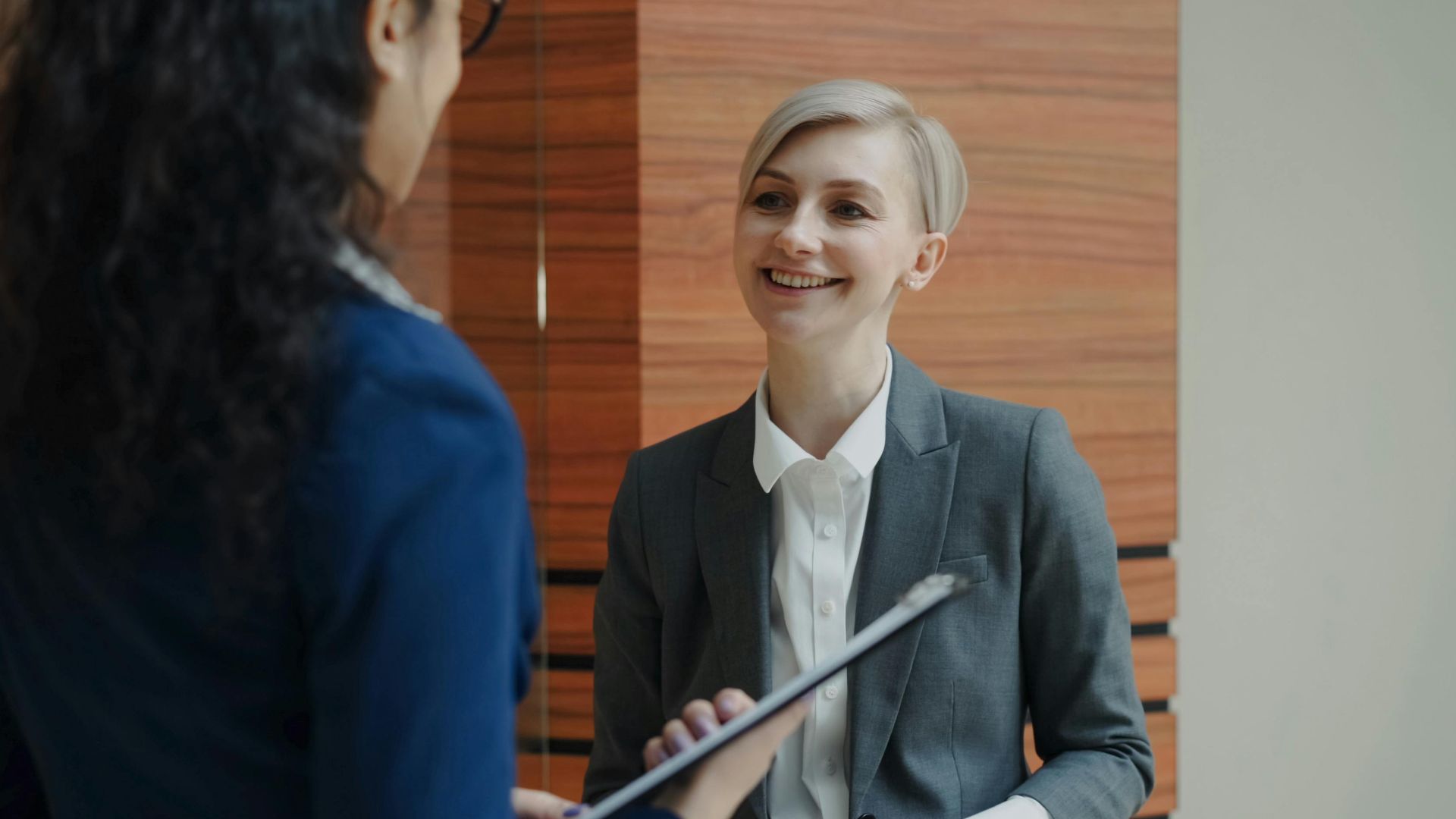 Two professionals having a conversation during a business meeting indoors.