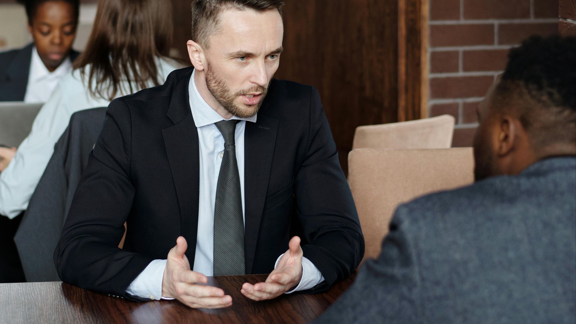 Professionals in suits having a focused business discussion in a stylish café.