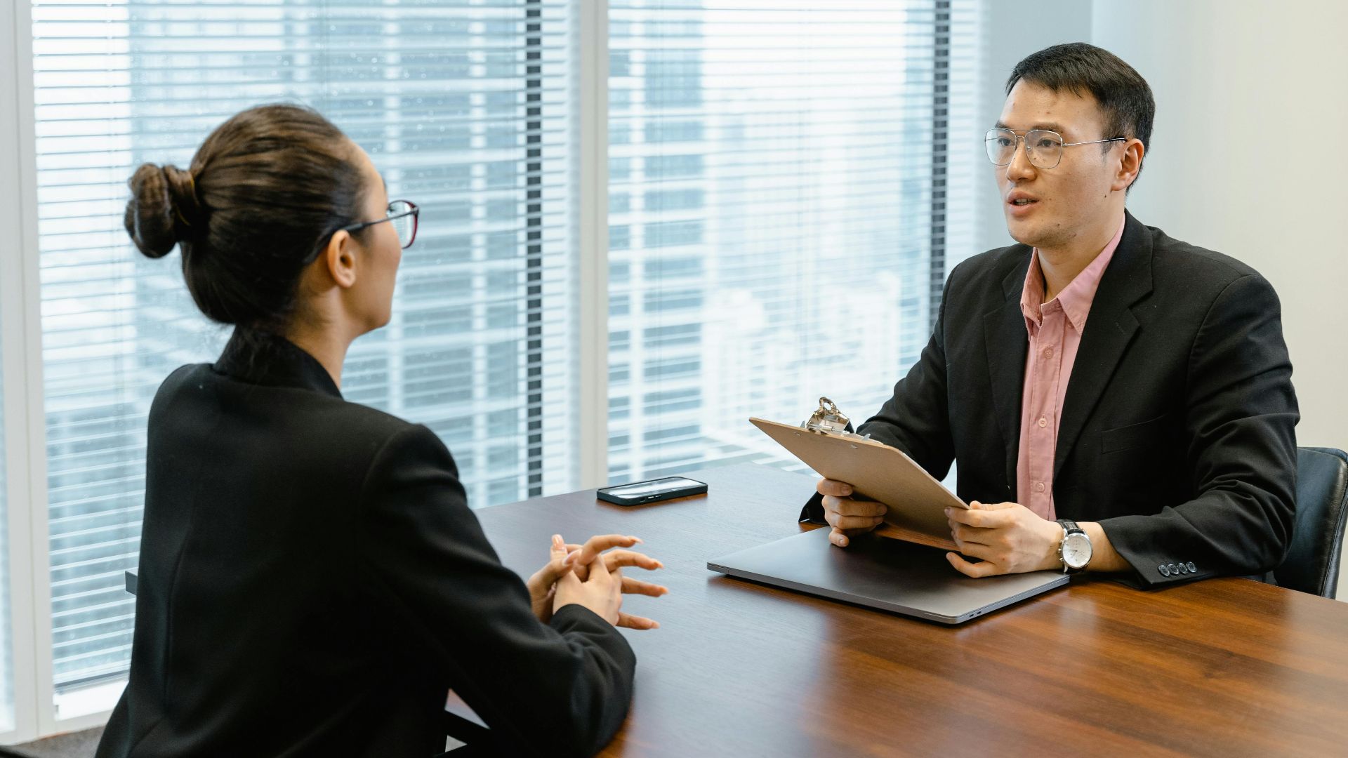 Professional business meeting in a modern office with two people discussing over documents.