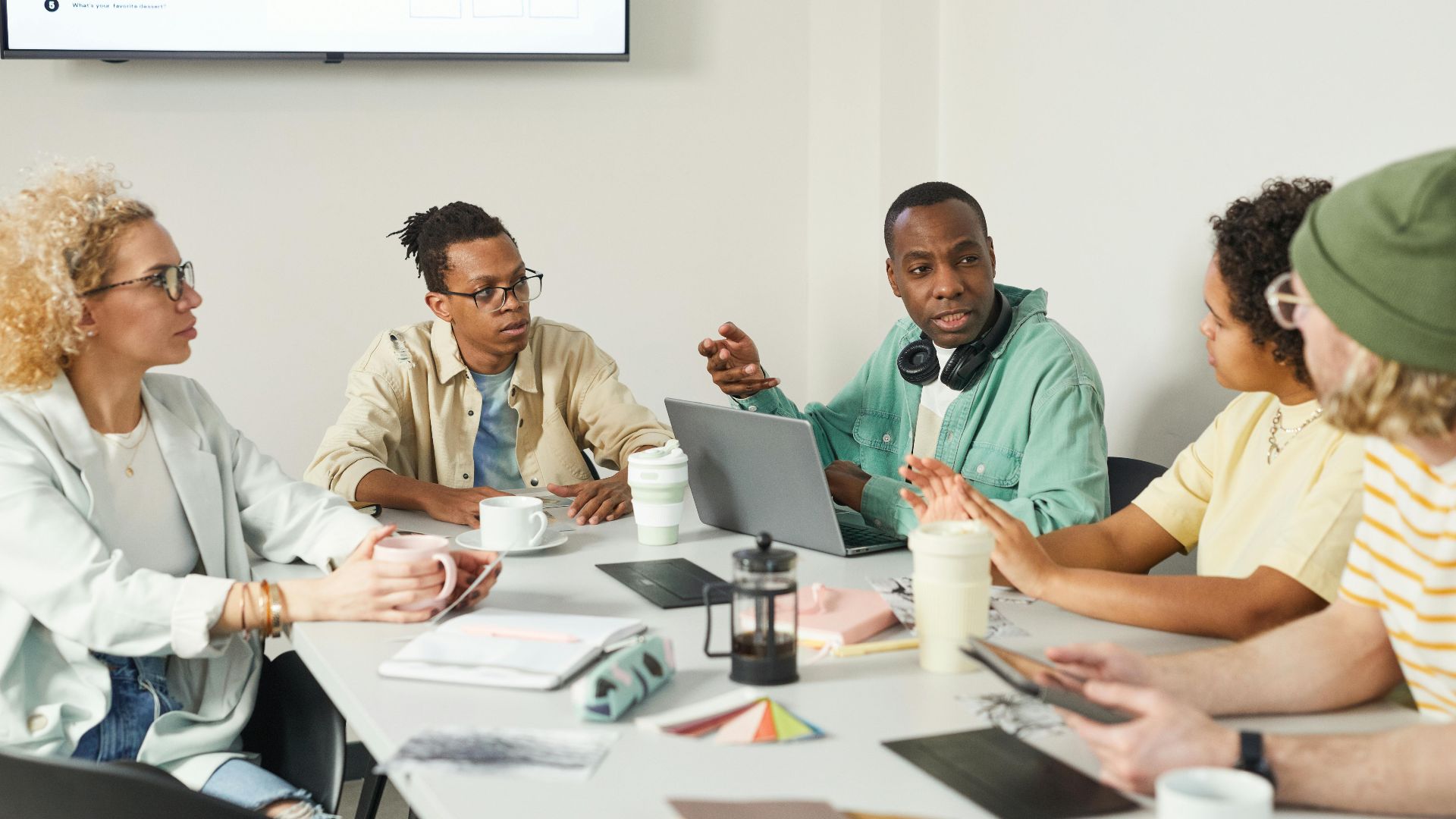 A diverse group of professionals engaged in a team meeting in a modern office setting.