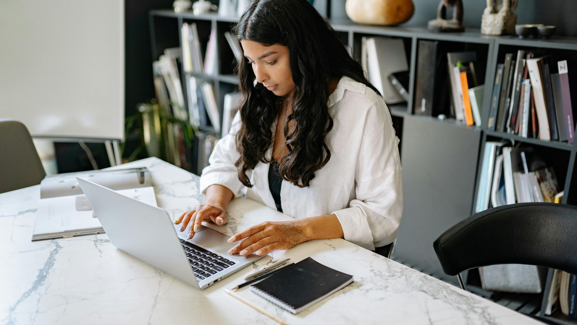 Confident businesswoman working on her laptop in a modern office setting. Perfect for business themes.
