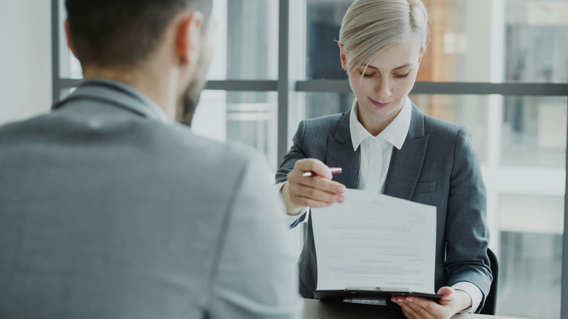 Woman in suit shows document to man