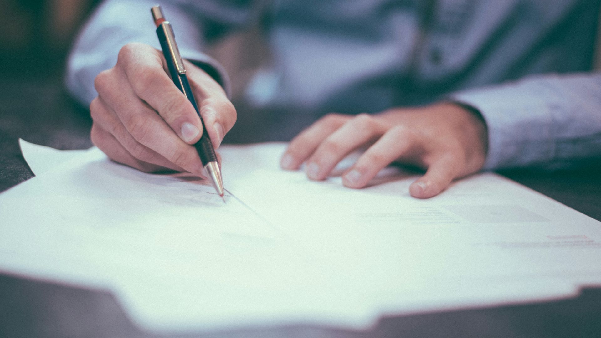 man writing on paper