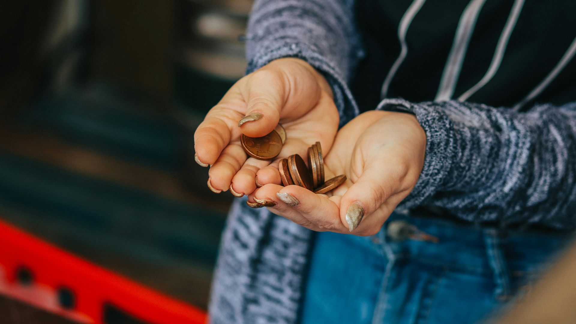 Close-up of a person's hands holding loose change at a Prague market.
