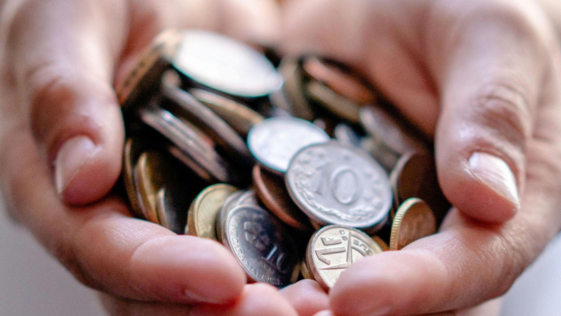 Crop anonymous person demonstrating heap of coins in hands demonstrating concept of savings