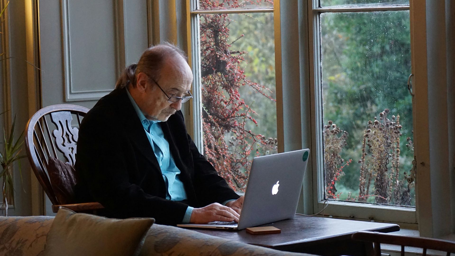 man in black suit jacket using macbook