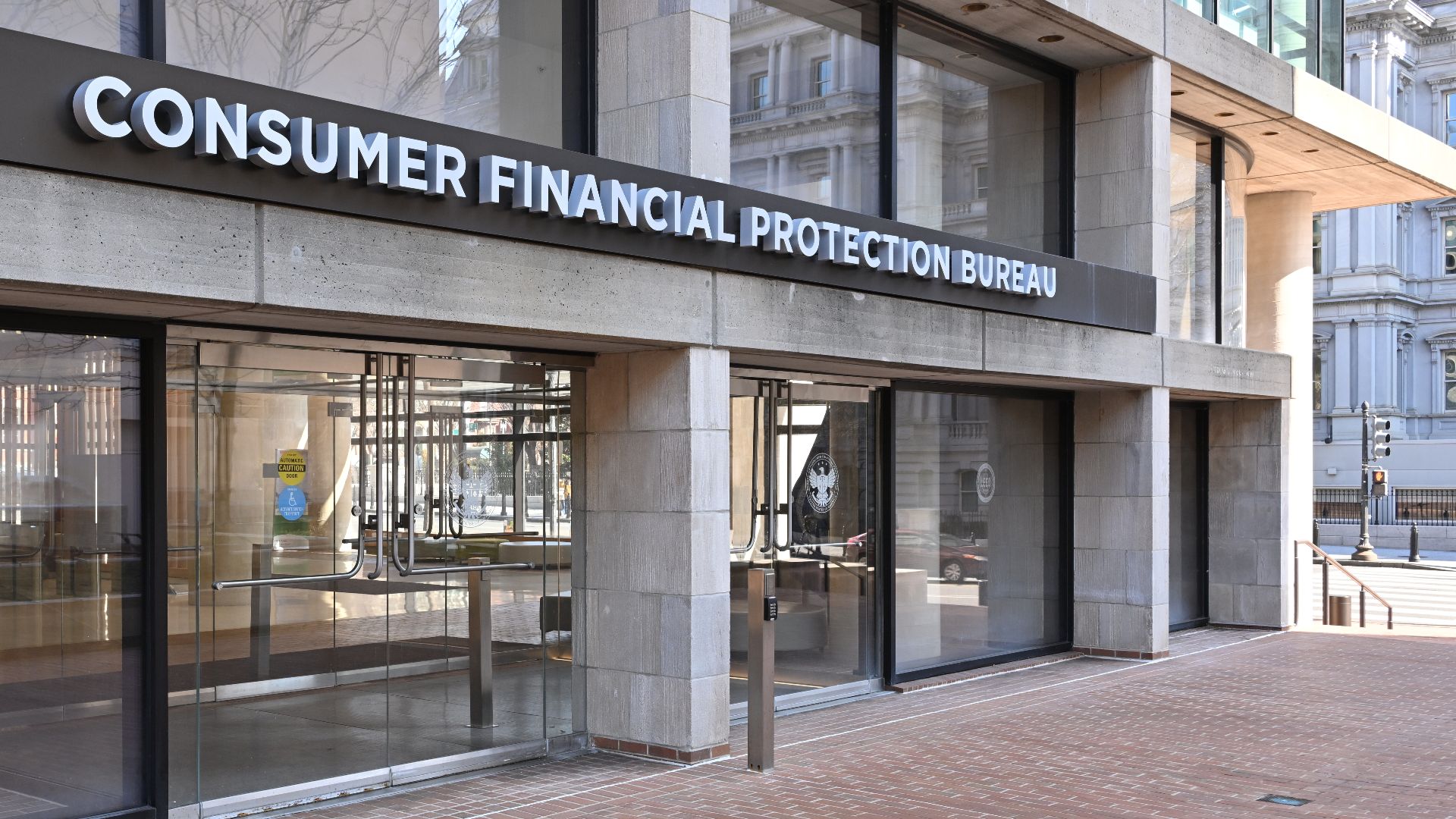 The entrance to the Consumer Financial Protection Bureau headquarters with the bureau's name above it. 1700 G Street NW, Washington, DC 20552.