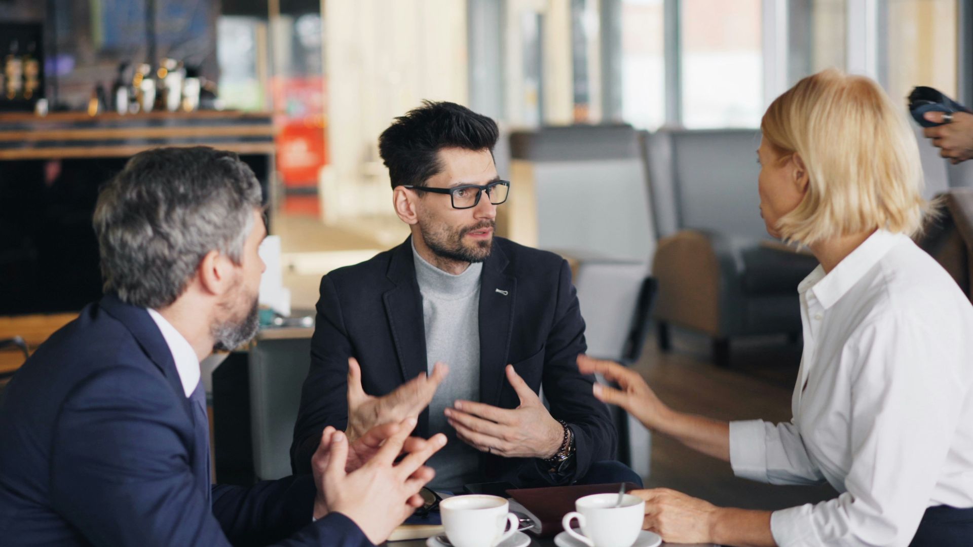a group of people sitting around a table talking