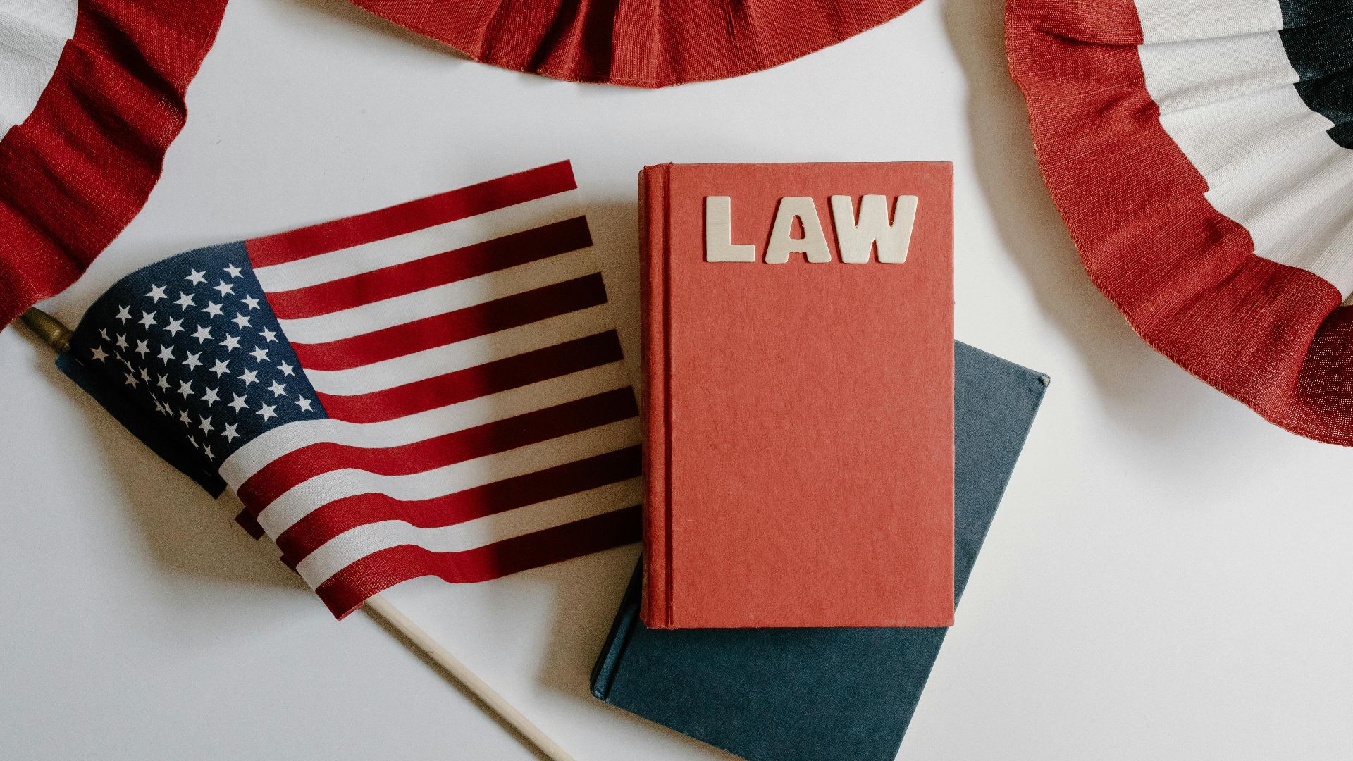 American flag with a law book, symbolizing independence and politics.