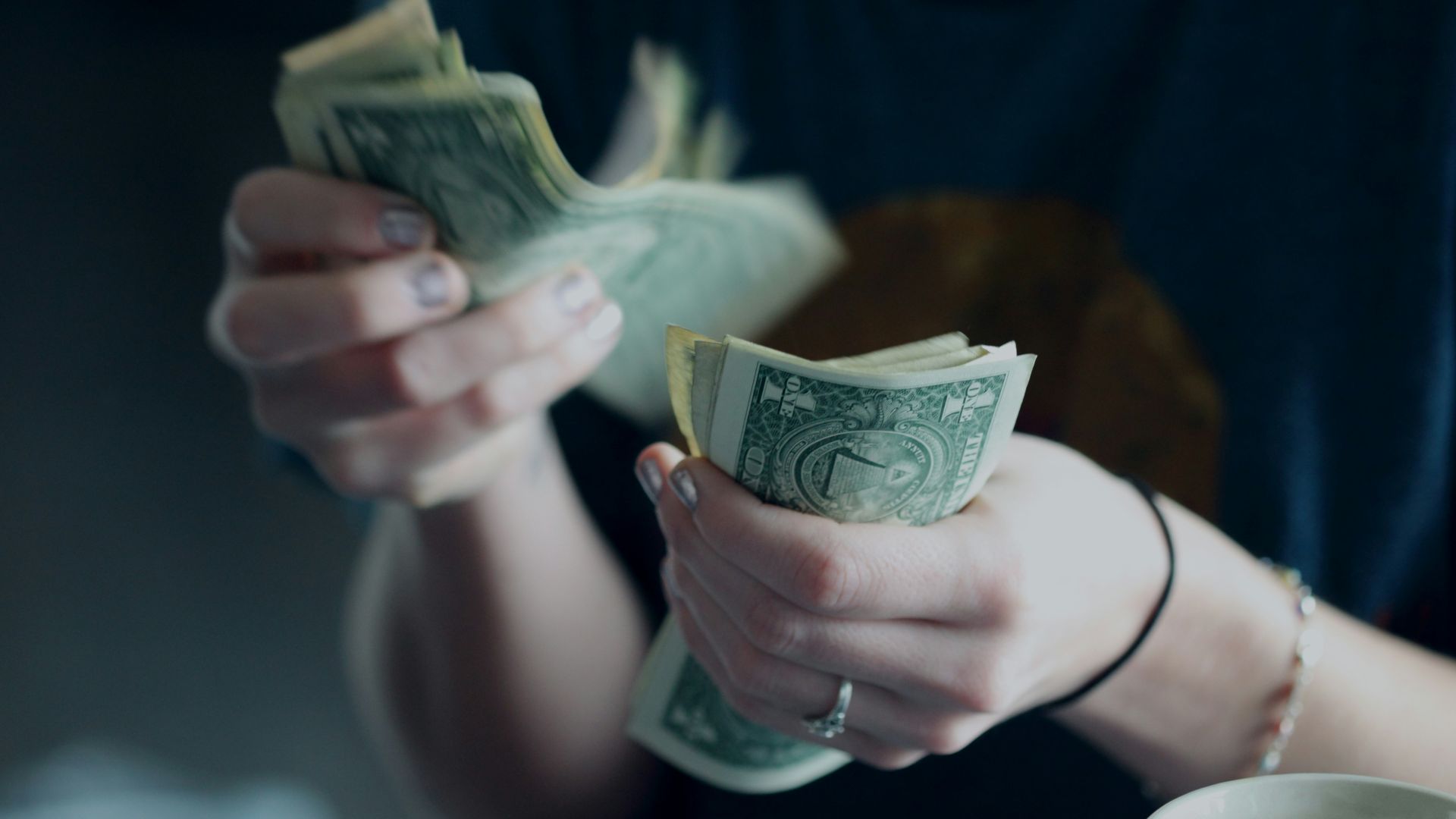 focus photography of person counting dollar banknotes