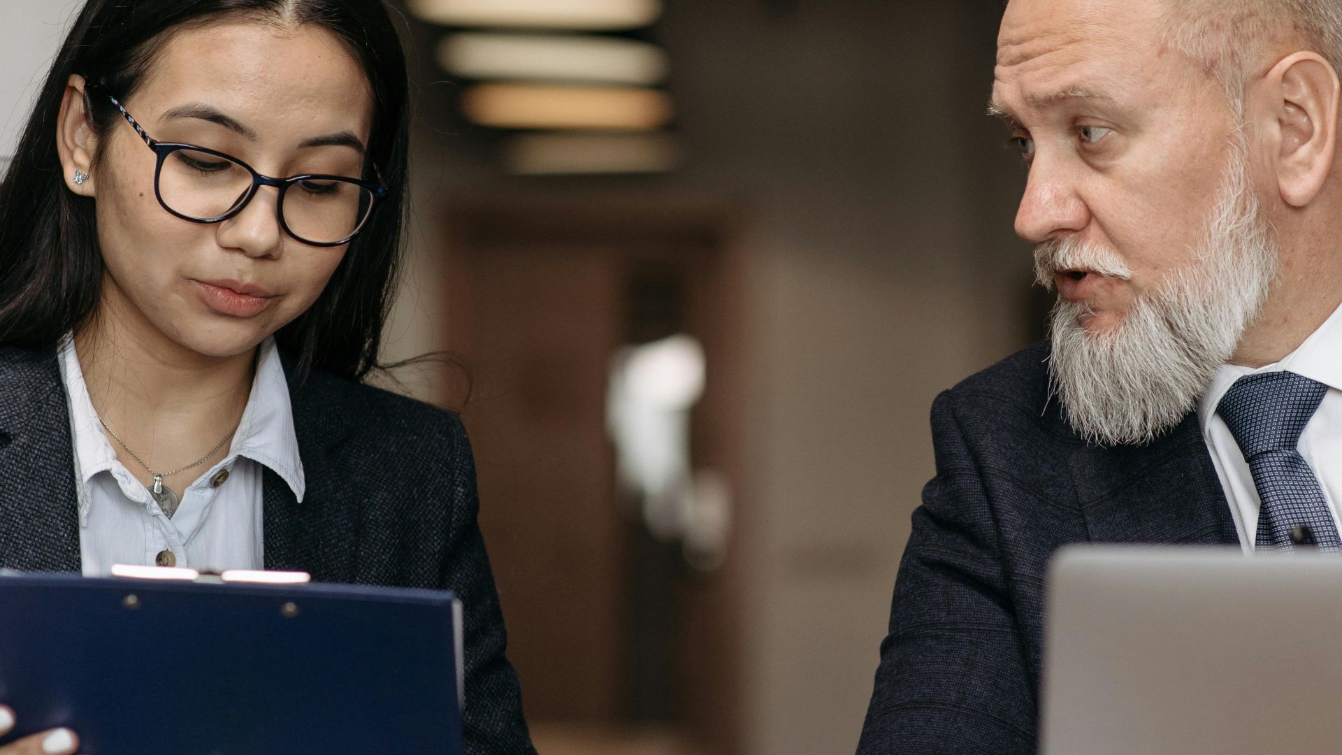 Corporate professionals discussing documents in a modern office setting.