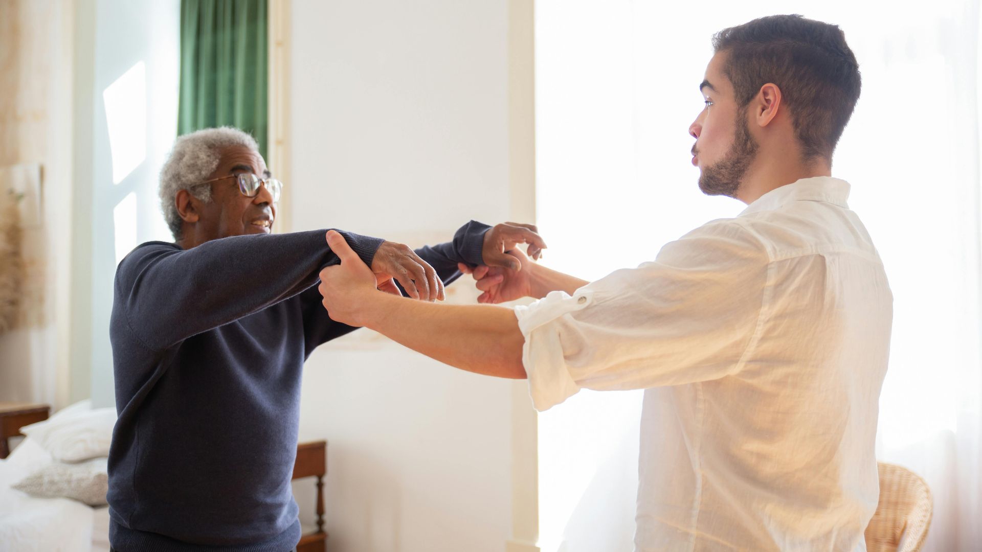 Senior receiving support from caregiver at home, showcasing care and communication.