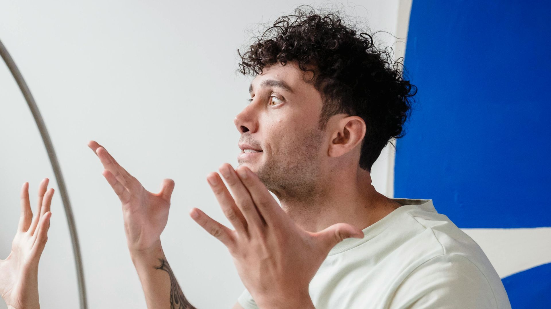 A couple argues indoors amidst greenery, showcasing emotions and interpersonal conflict.