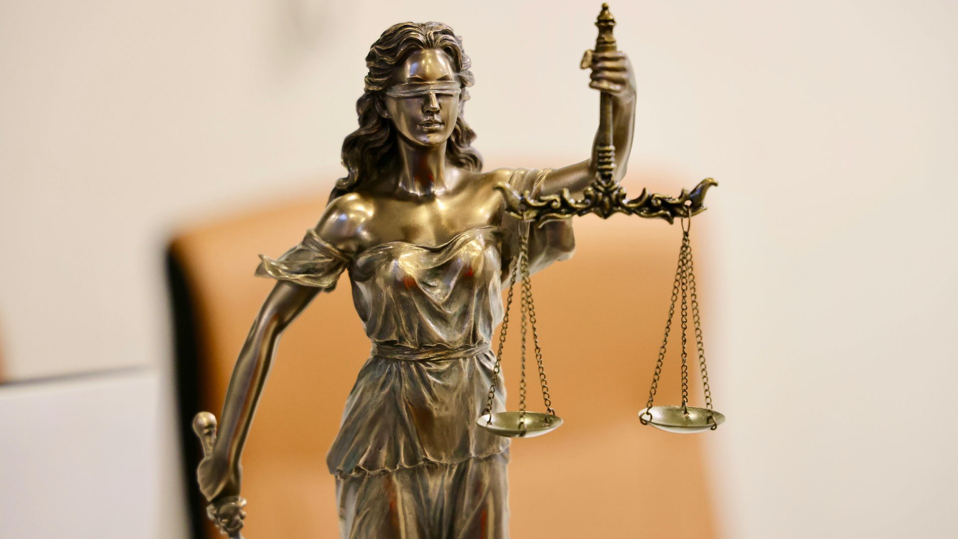 Close-up of Lady Justice statue holding scales, symbolizing justice and fairness.