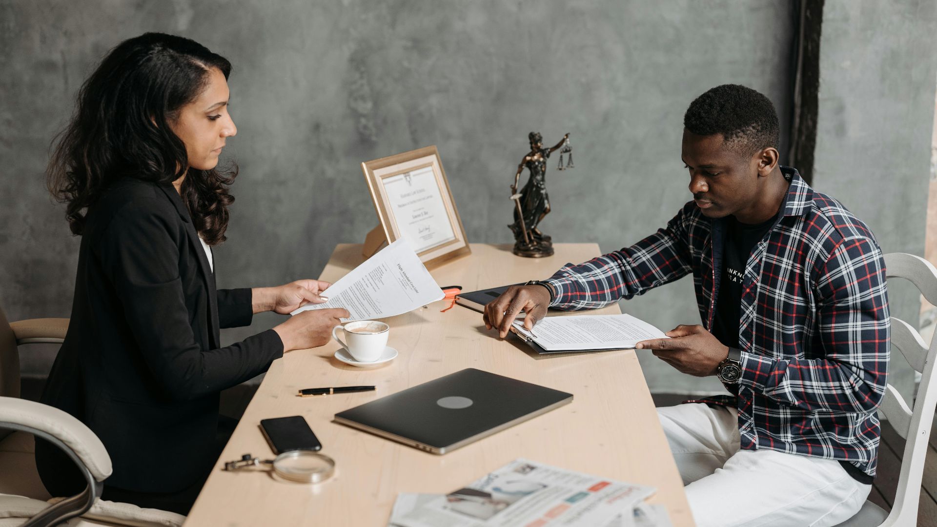 Business professionals discussing documents in a modern office setting.