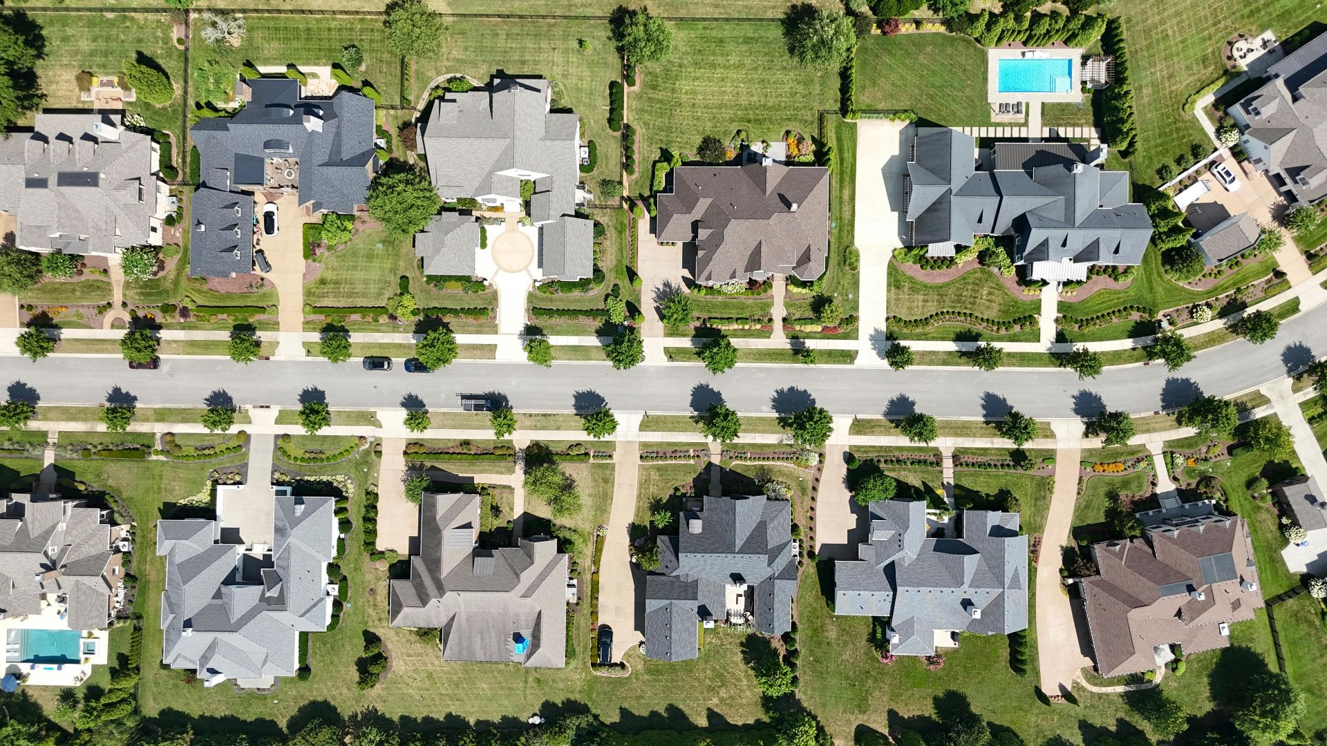 Overhead shot of beautiful homes in a suburban Tennessee neighborhood, showcasing lush greenery and modern architecture.