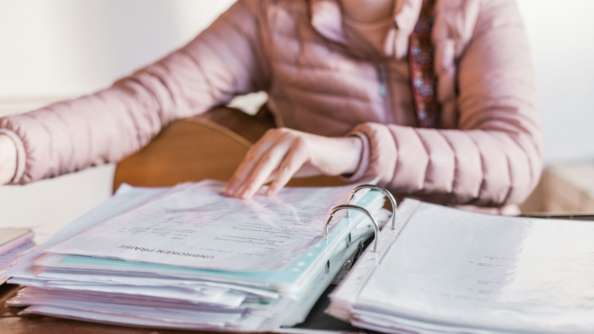 woman in white long sleeve shirt sitting beside brown wooden table