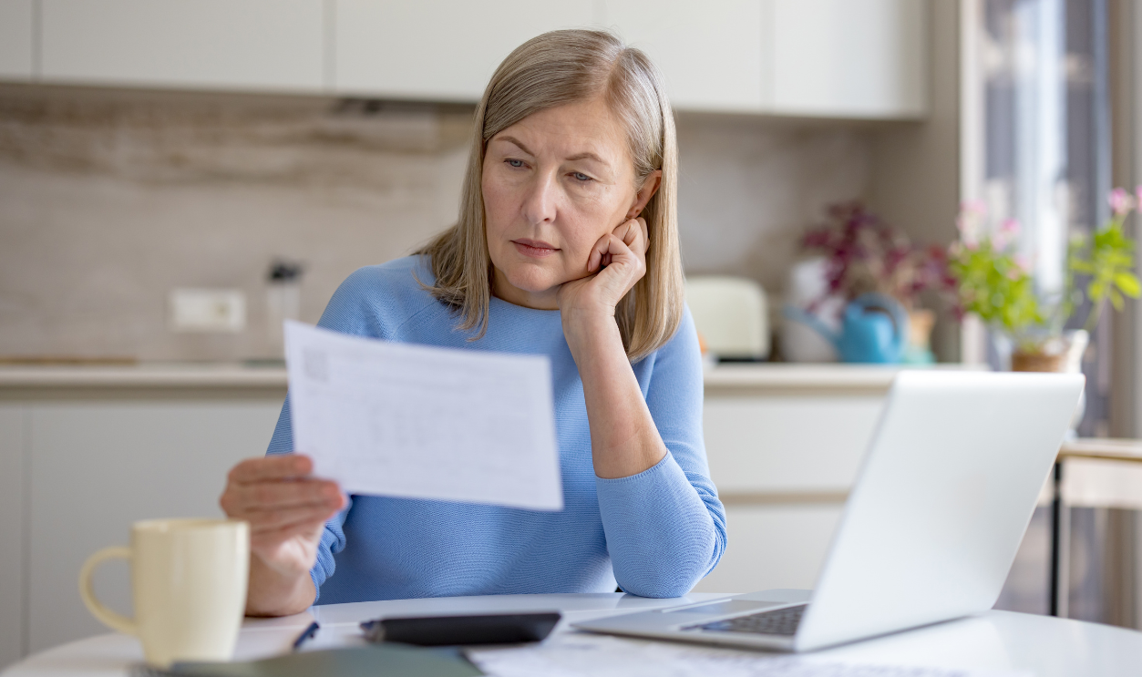 Mature woman analyzing financial documents and bills