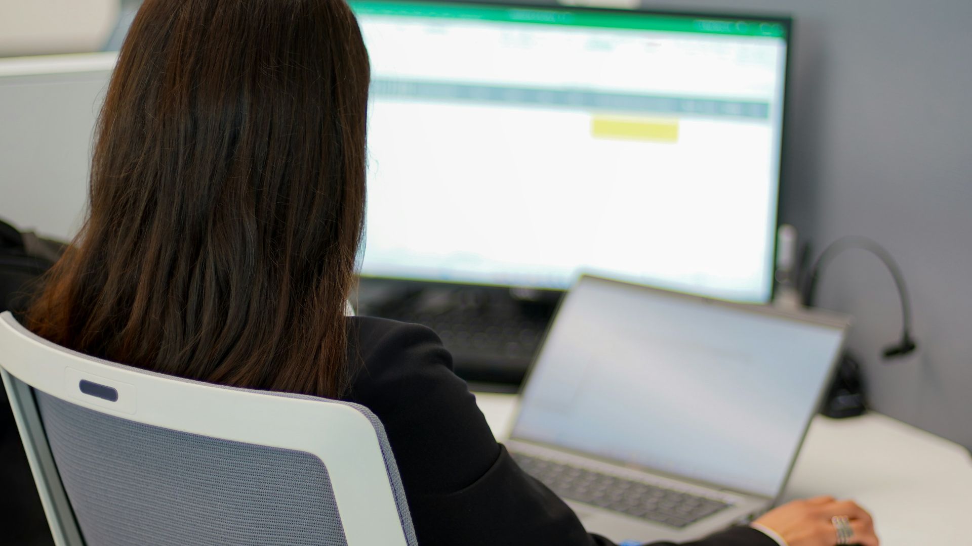 a woman sitting in front of a laptop computer