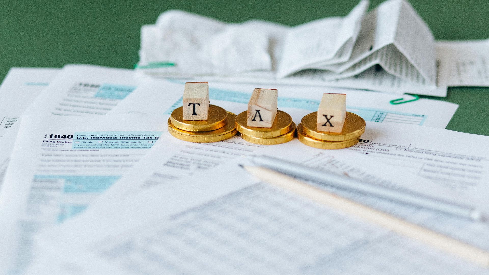 Close-up of tax forms, receipts, and coins symbolizing financial accounting and taxes.