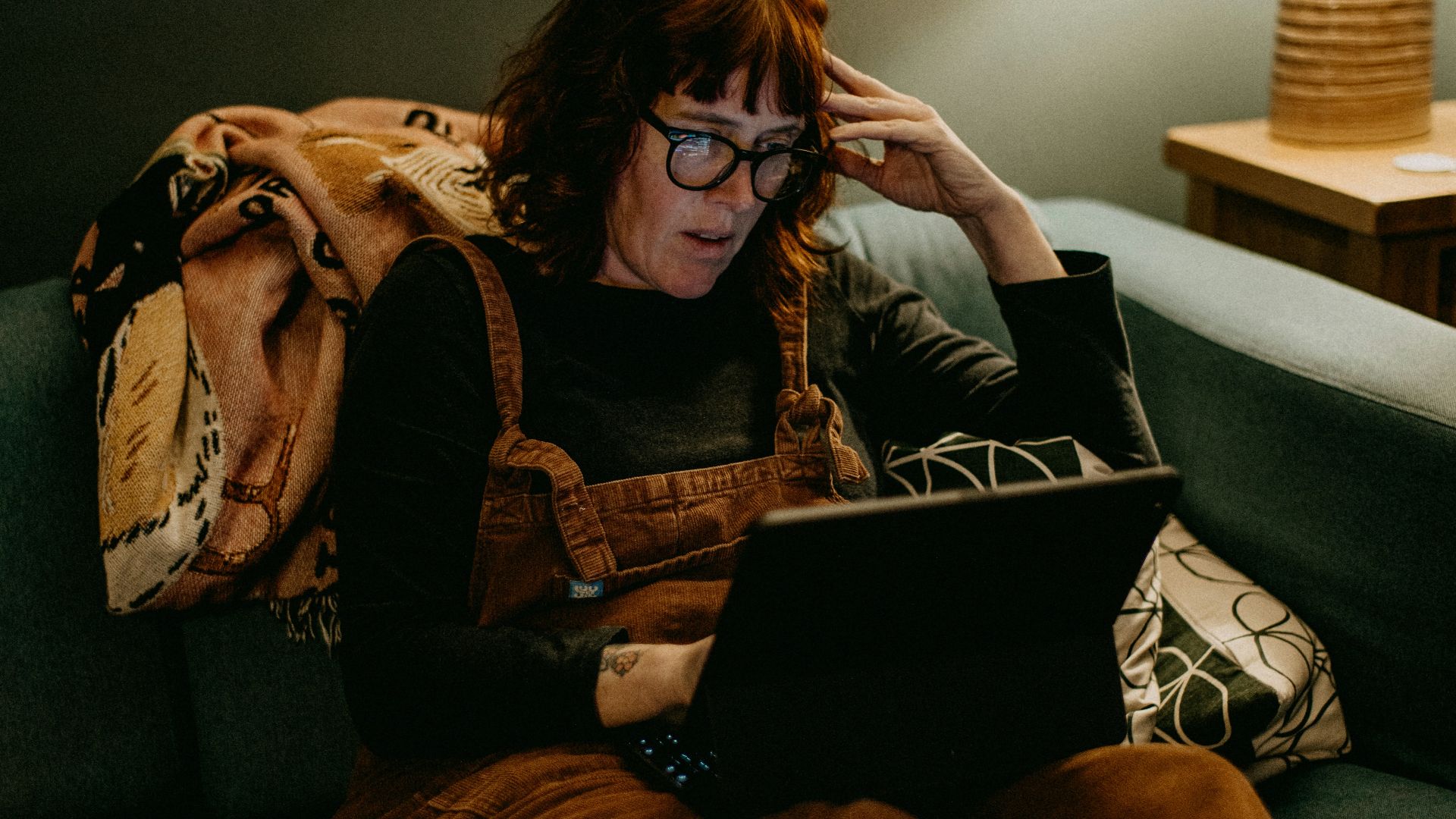 a woman sitting on a couch using a laptop computer