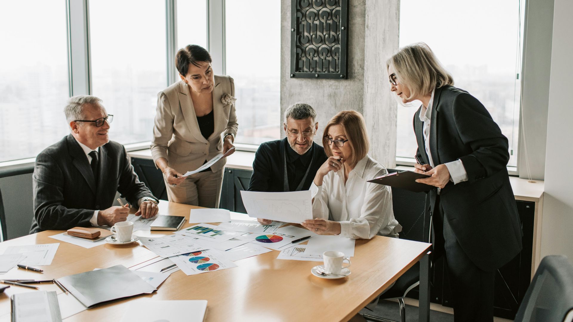 Business professionals engage in an office meeting to analyze data and strategies.