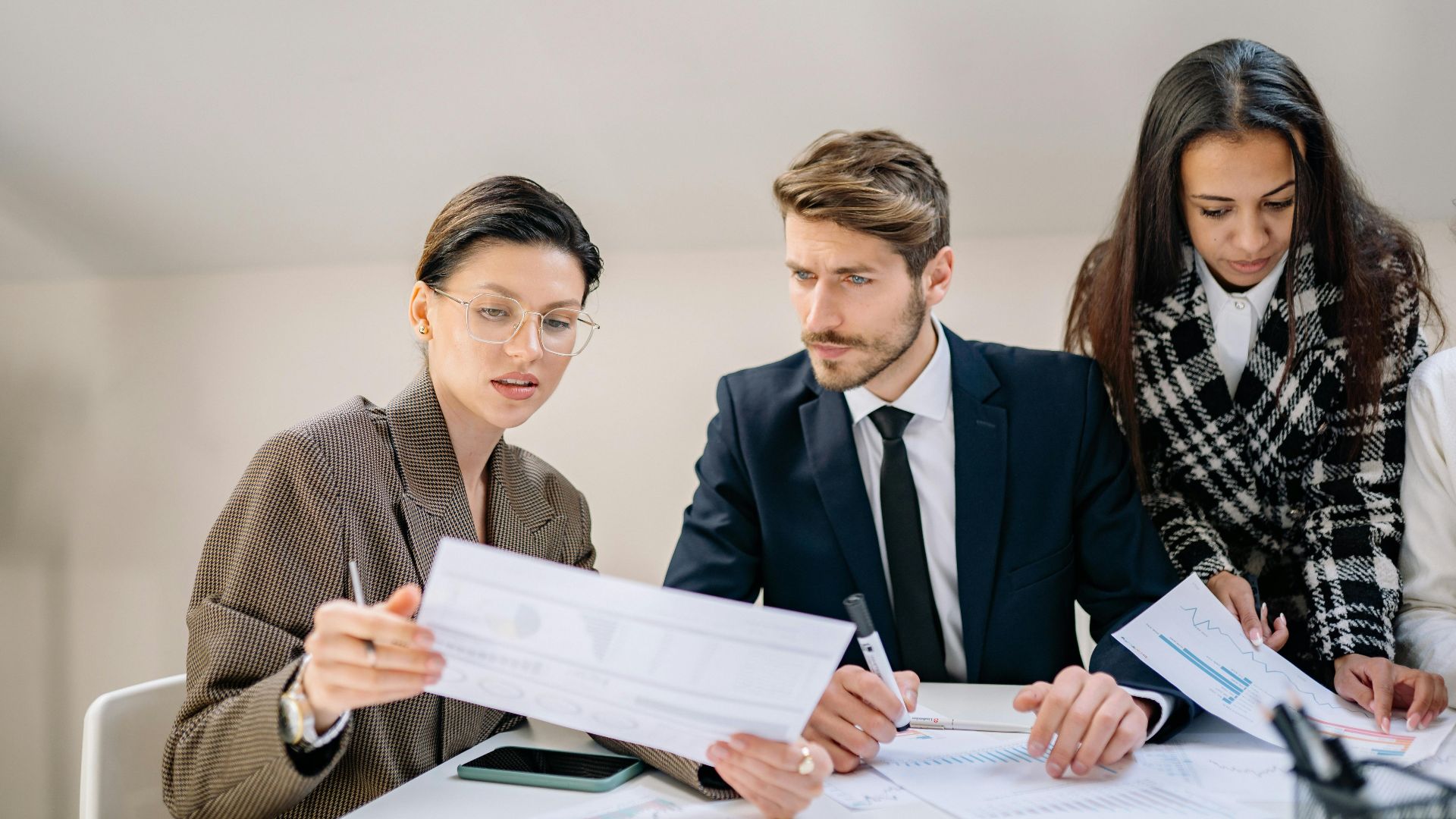 A group of employees reviewing documents in a modern office setting, fostering teamwork and collaboration.
