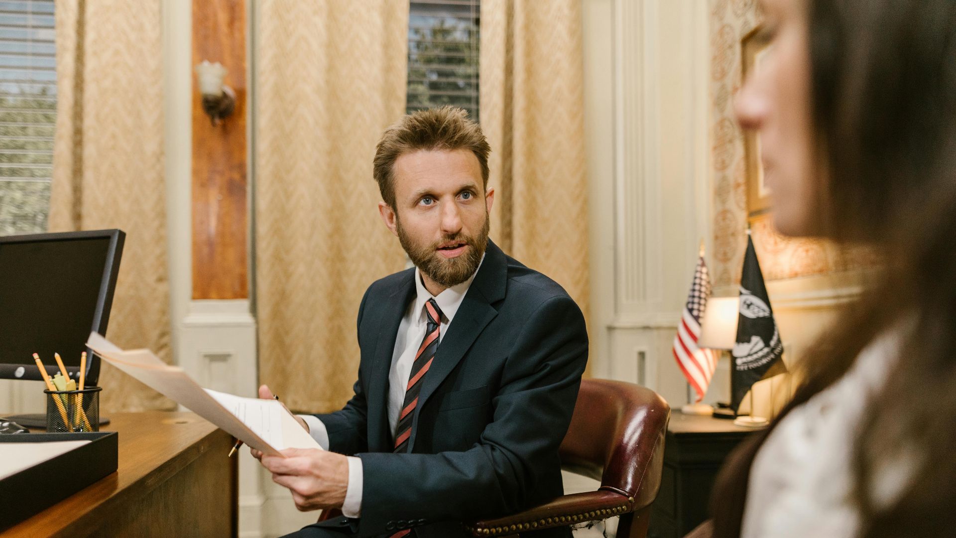 Businessman in suit discussing legal documents in office environment.