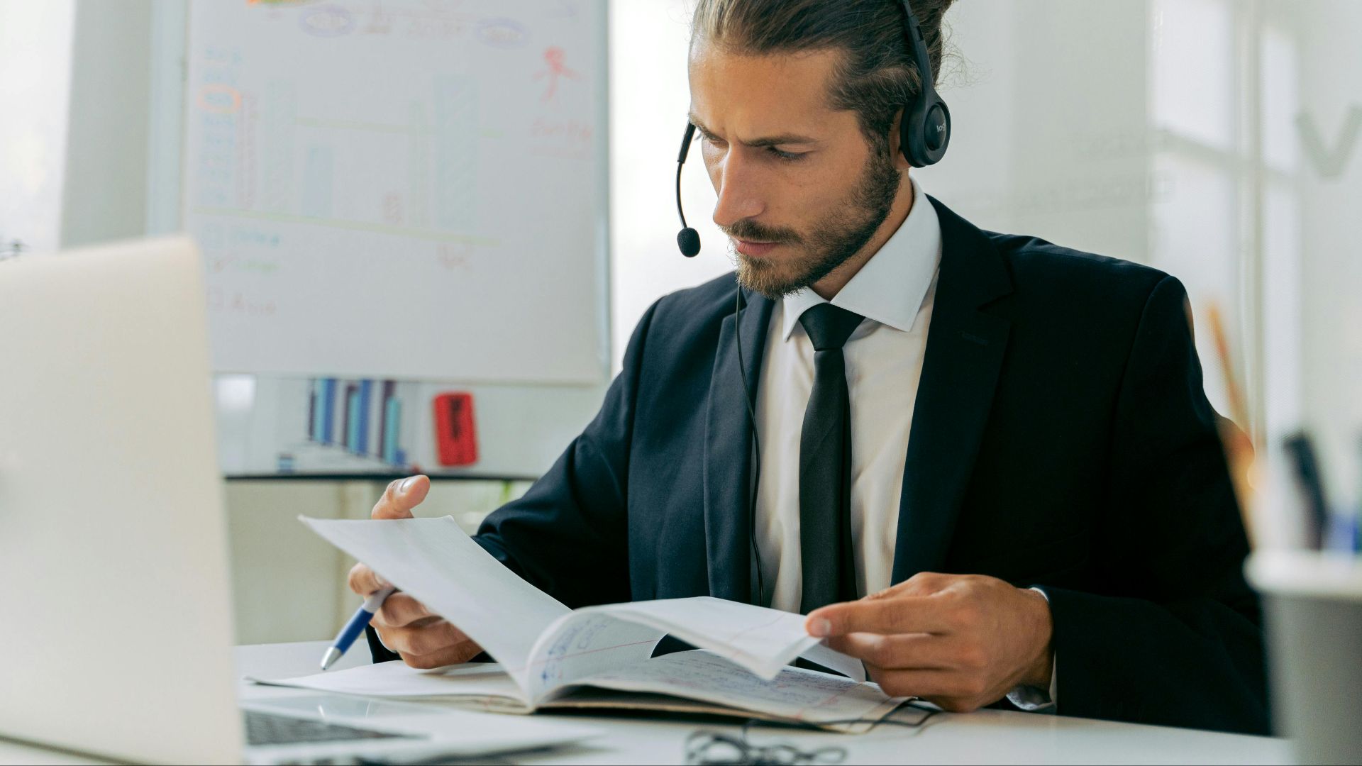 Focused business professional handling customer service tasks with a headset in an office setting.