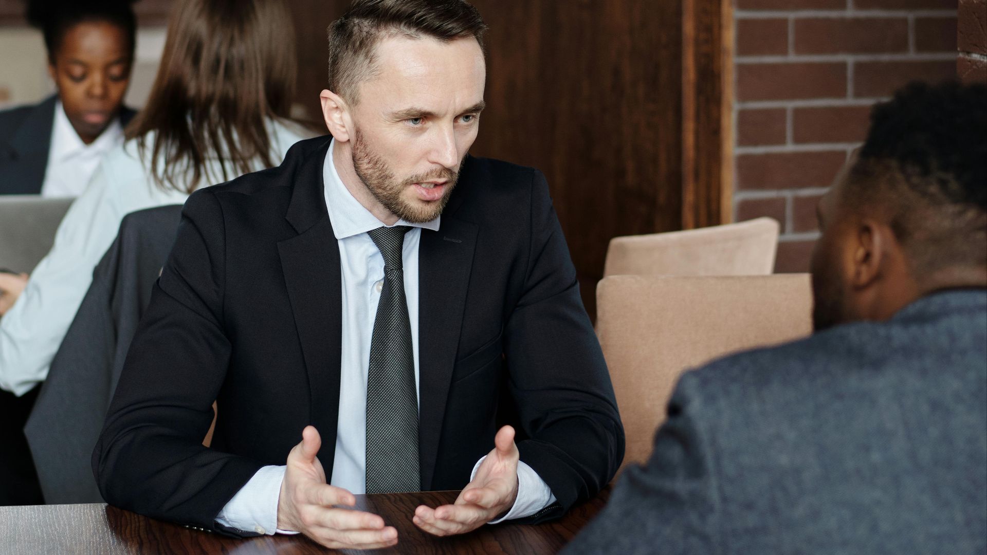 Professionals in suits having a focused business discussion in a stylish café.