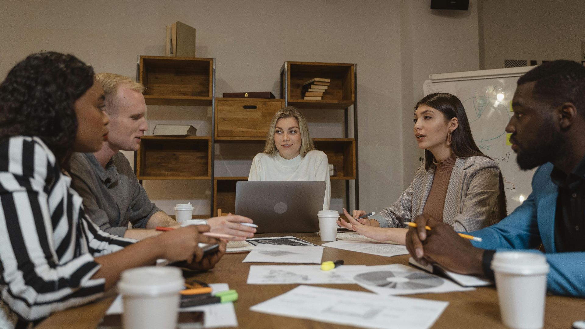 Group of professionals collaborating in a modern office setting during a strategic meeting.
