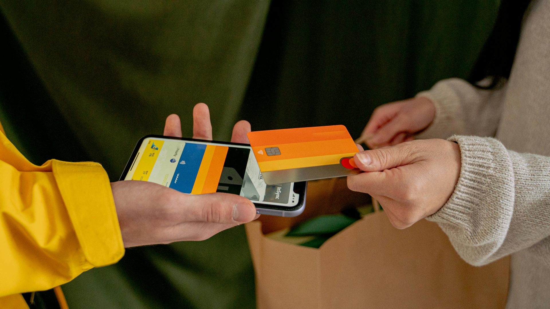 A close-up of a contactless payment using a credit card and smartphone, highlighting modern technology.