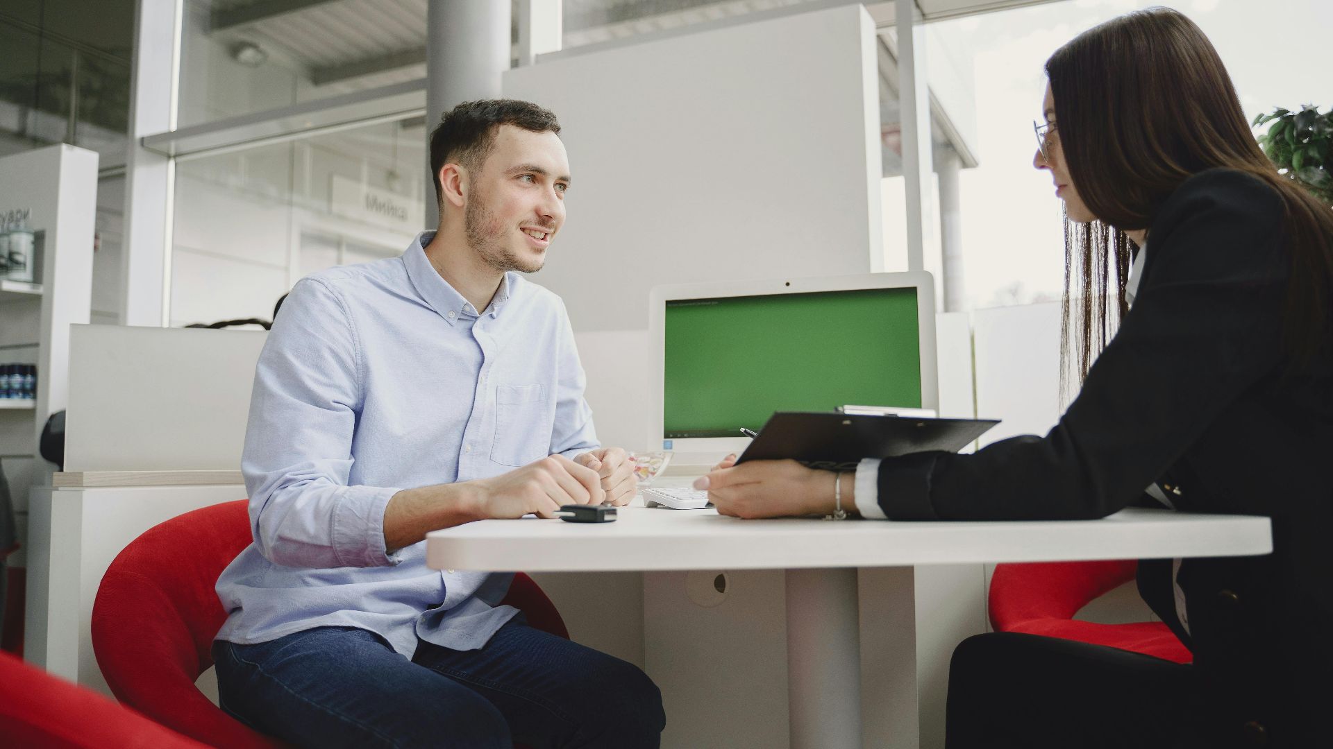 A man and woman engaged in a professional meeting at a modern office table.