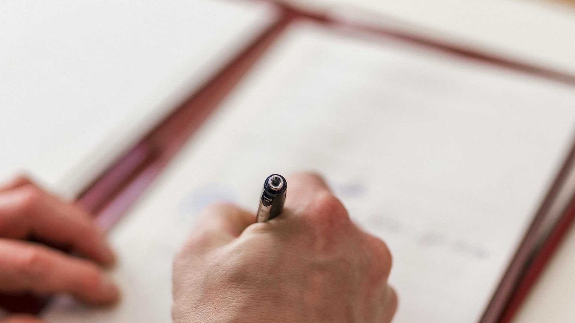 Close-up of a businessman signing a document in a formal office environment.