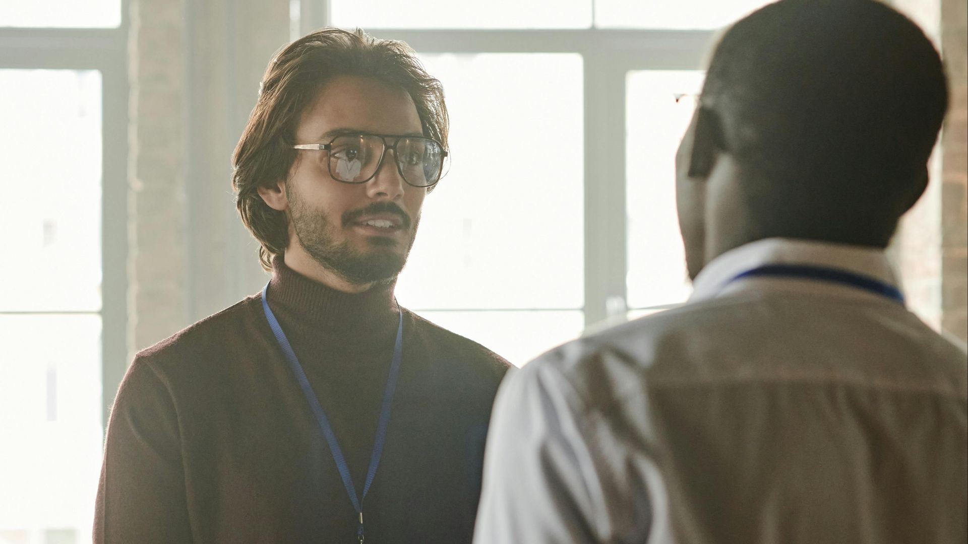 Two business professionals engage in a discussion in a modern office setting.
