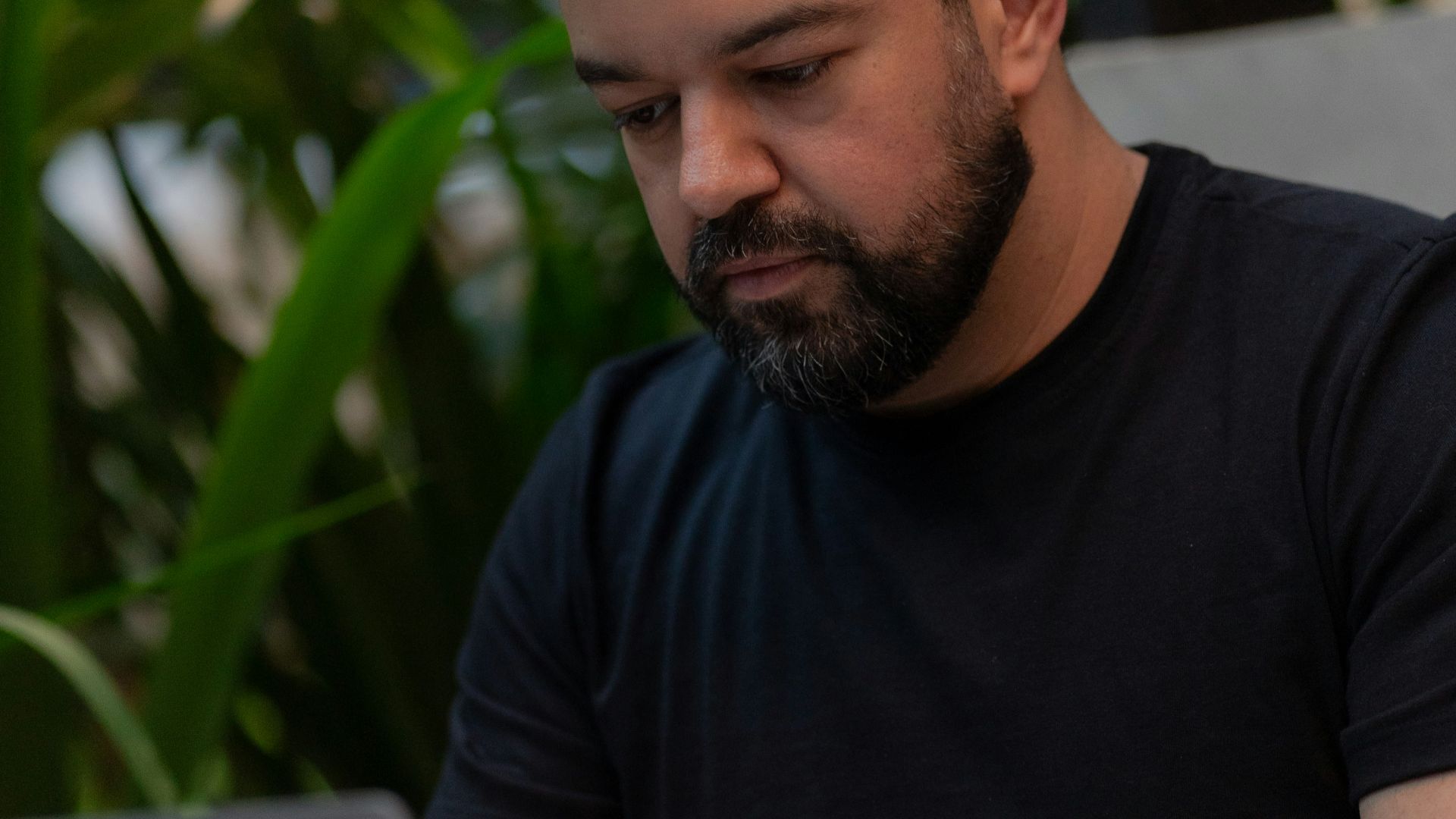 A man sitting at a table using a laptop computer