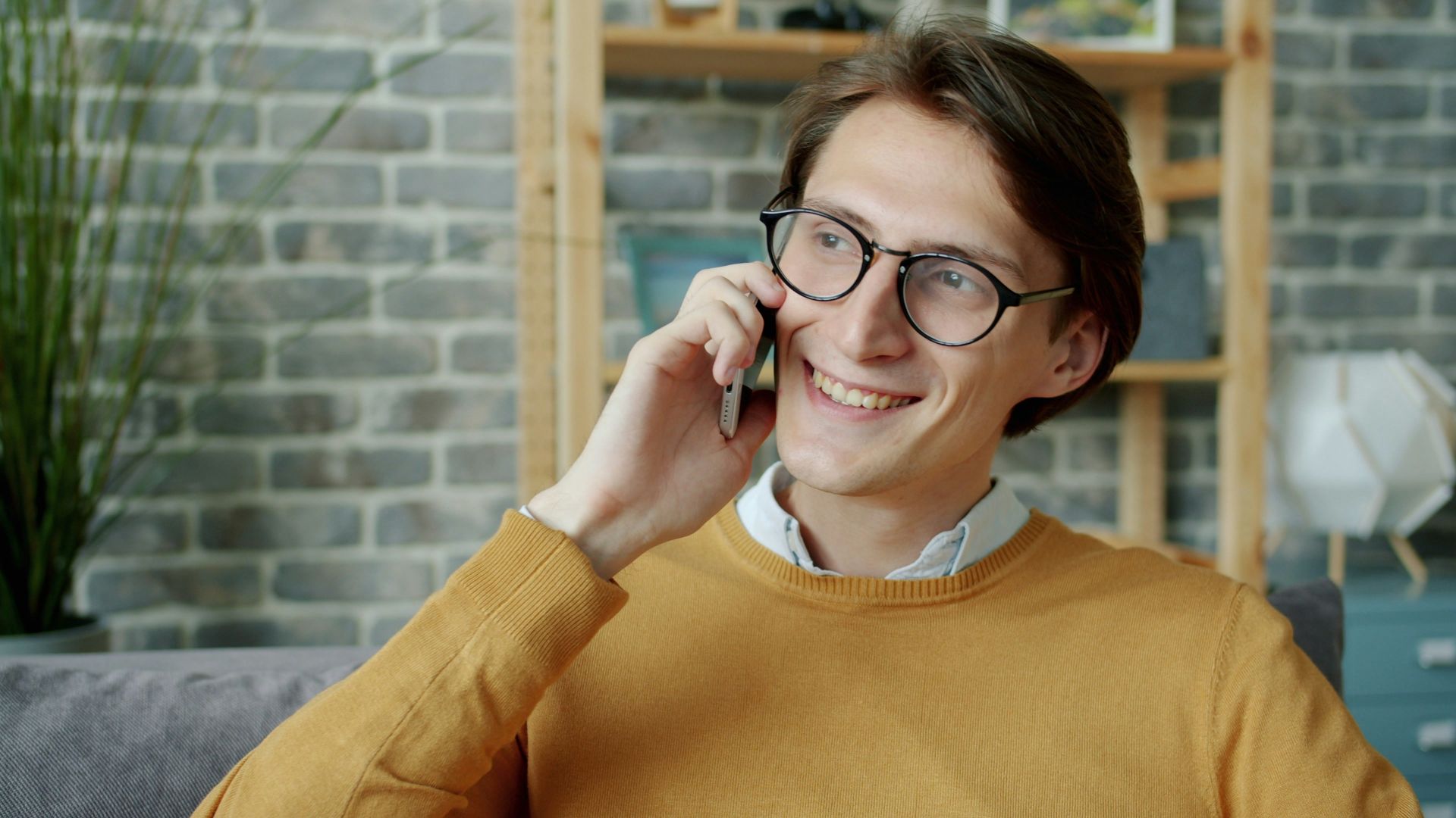 Young man in glasses talking on a smartphone.