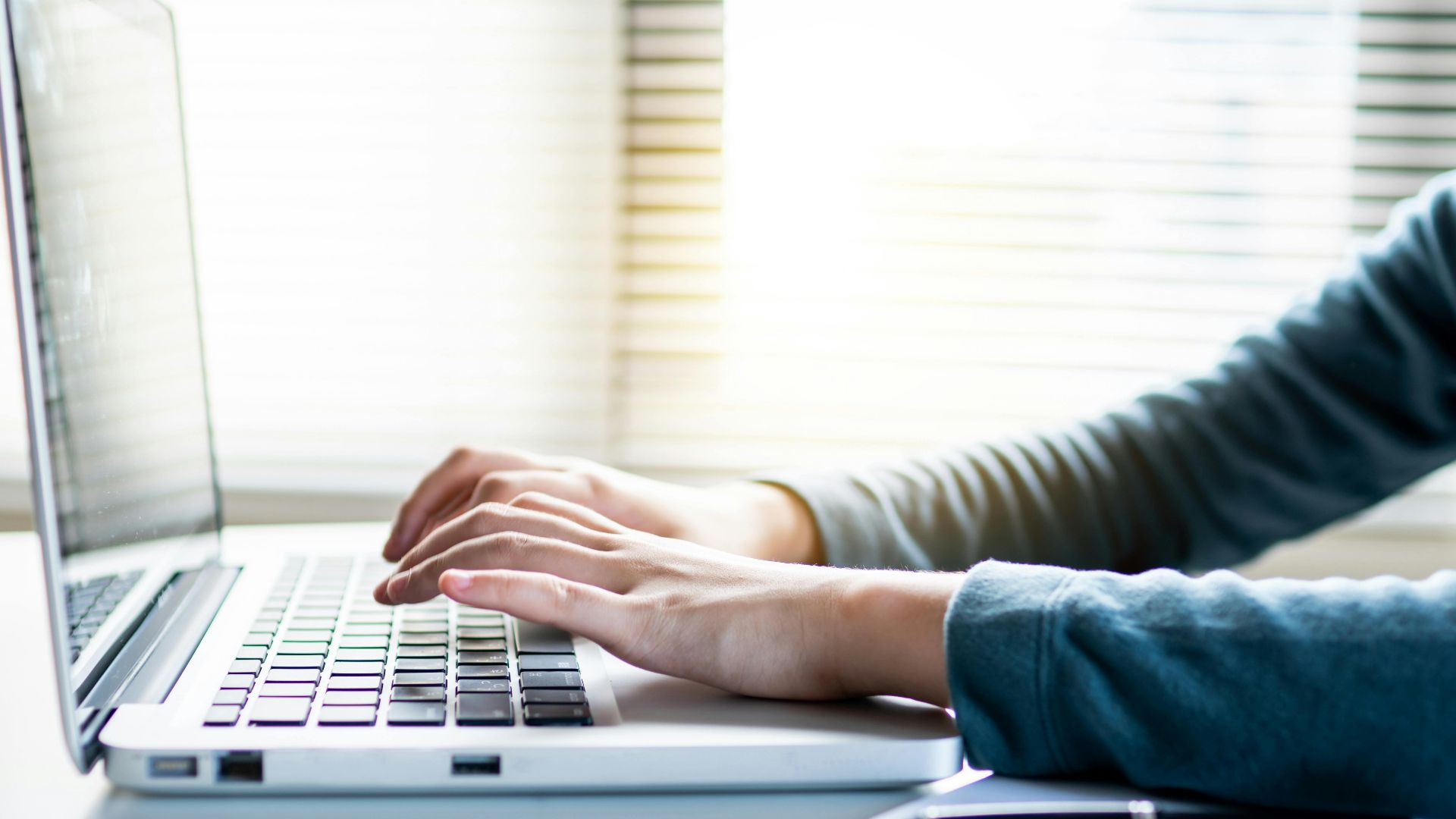 Close-up shot of hands typing on a laptop keyboard, perfect for business or technology themes.