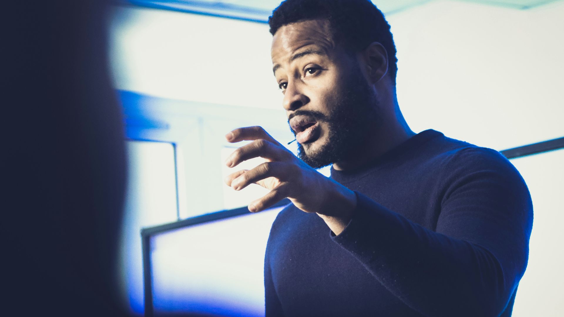 A man standing in front of a projection screen