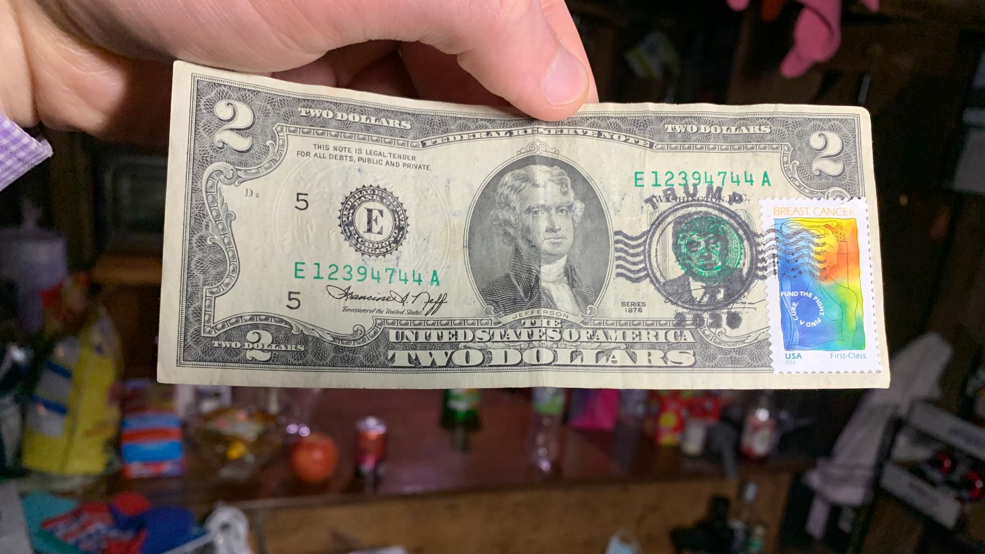 American two dollar bill which has been defaced with advertisements and political slogans