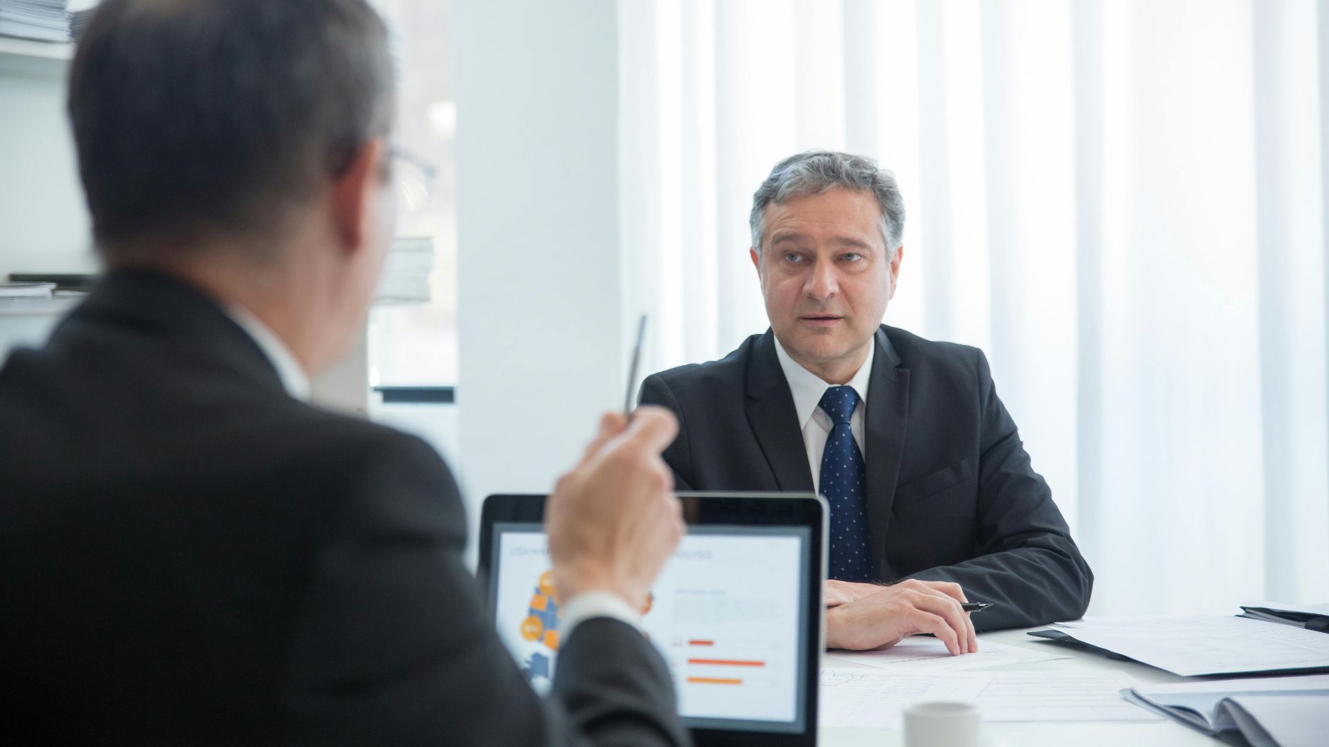 Business professionals in a focused discussion during an office meeting.