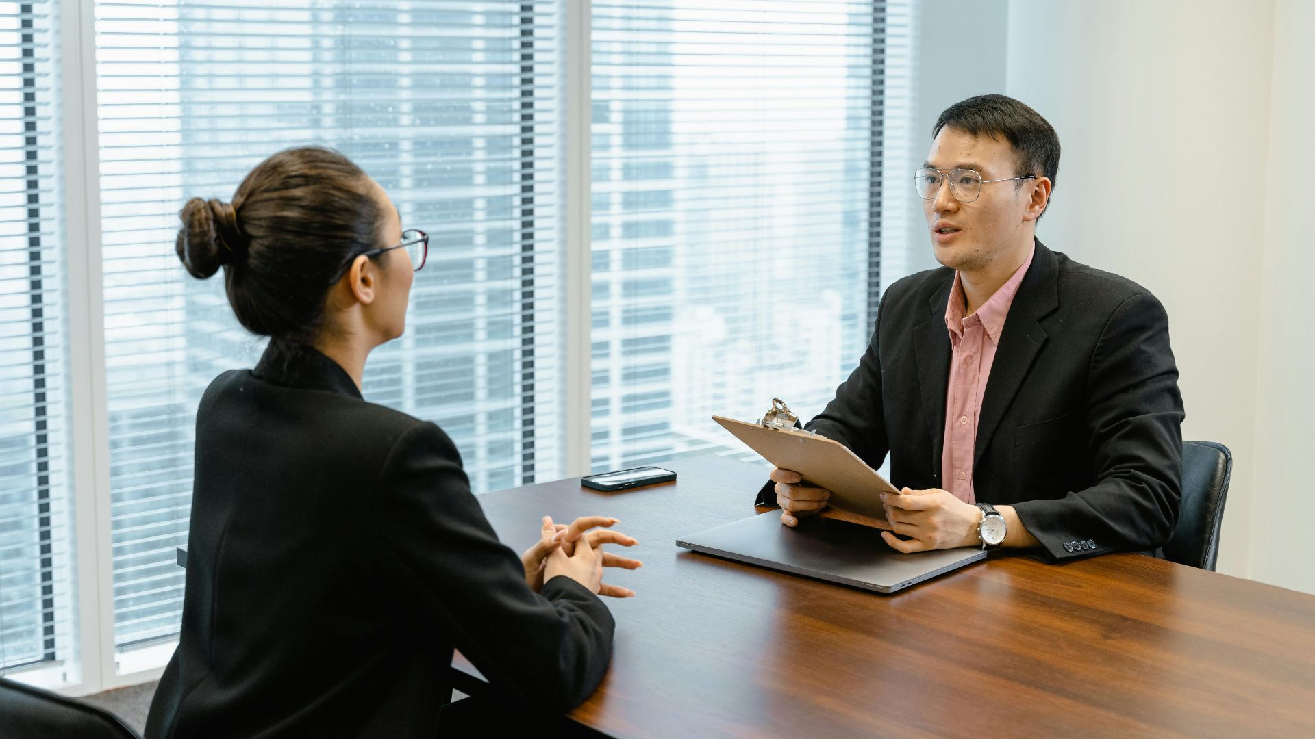 Professional business meeting in a modern office with two people discussing over documents.