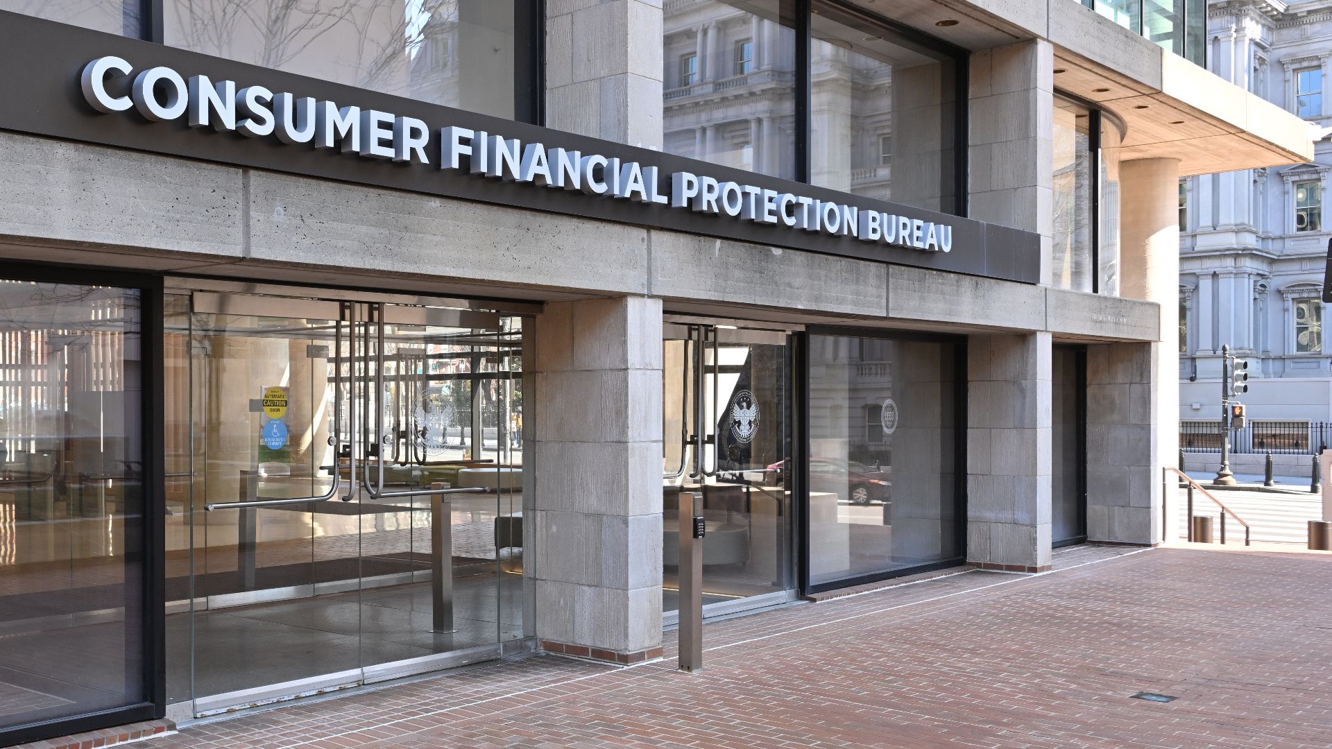The entrance to the Consumer Financial Protection Bureau headquarters with the bureau's name above it. 1700 G Street NW, Washington, DC 20552.