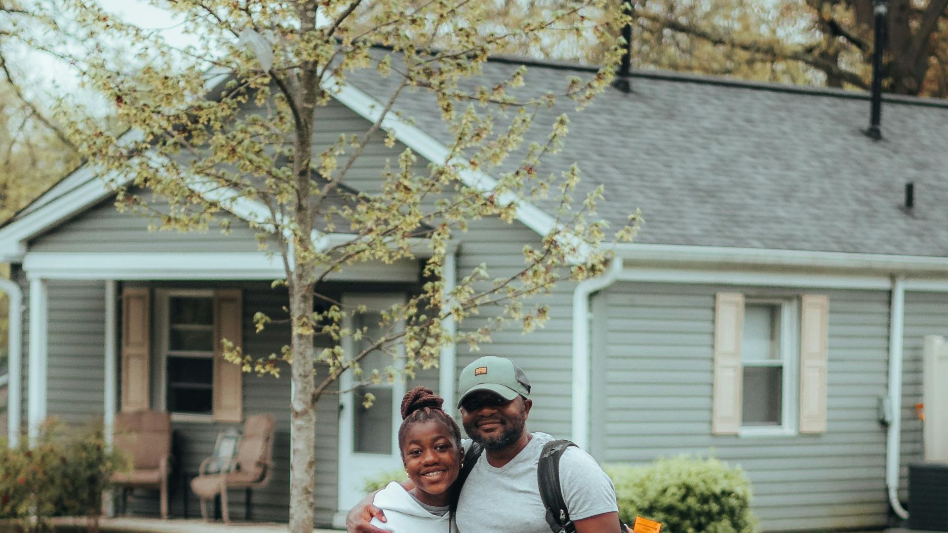 A joyful couple embraces on a suburban street, showcasing happiness and togetherness.