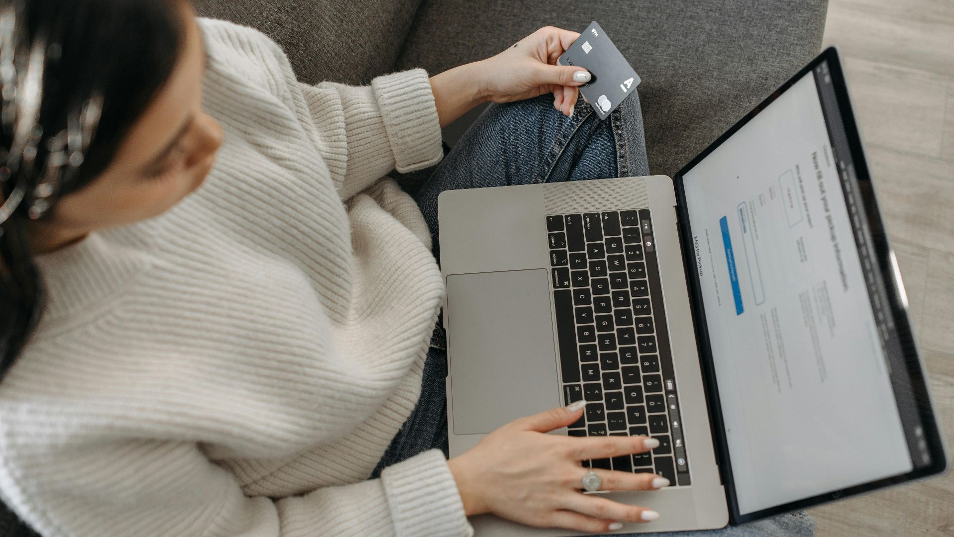 Young woman shopping online using her laptop and credit card from home.