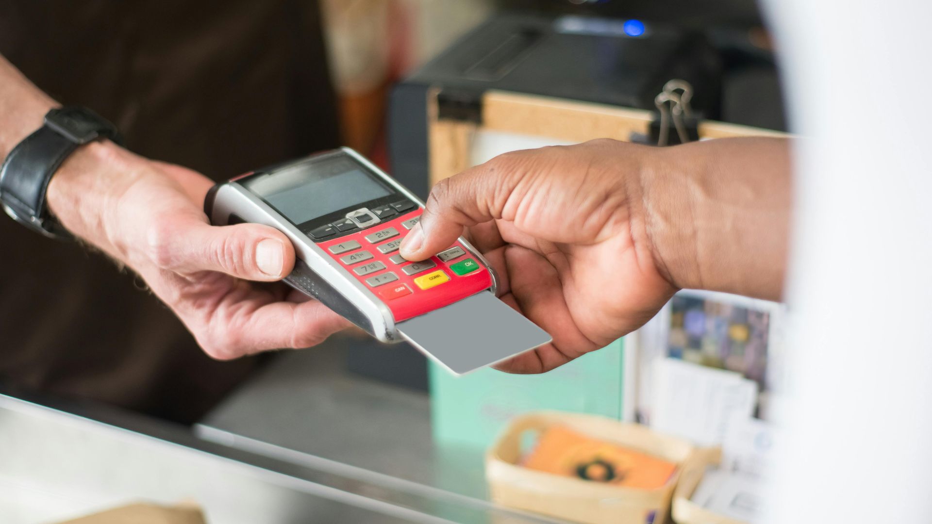 A customer uses a card for a contactless payment at a retail store. Business and consumerism concept.