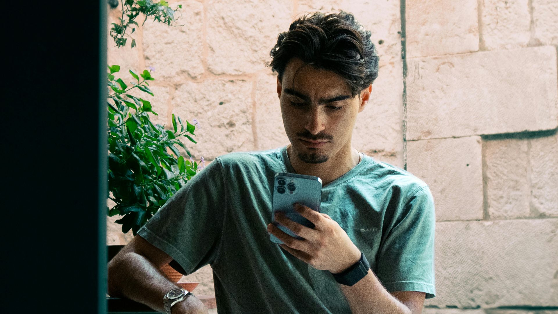 A young man in casual attire checking his phone outside in Split, Croatia.