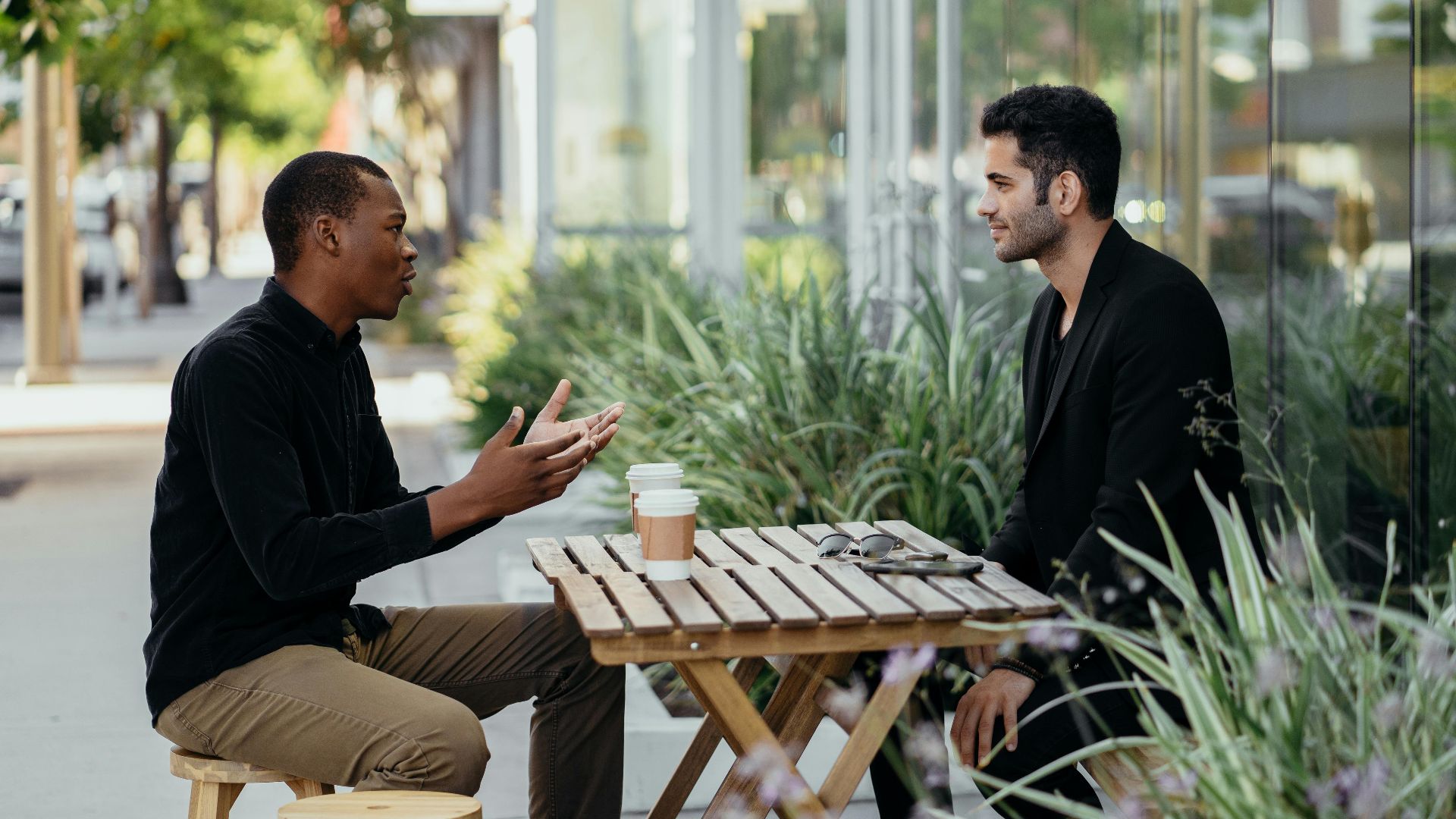 Two men having a business meeting at an outdoor café setting.